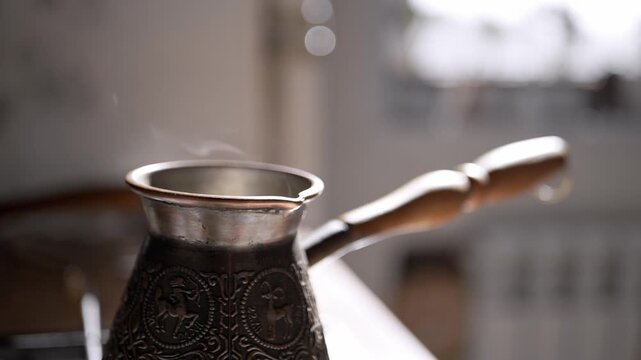 A traditional copper coffee pot sits on a stove with hot steam rising slowly in soft cinematic backlight. Concept of morning energy, authentic brewing methods, and cozy home atmosphere.