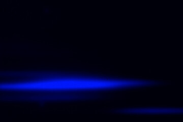 Fototapeta premium Deep blue glowing light streak on black background. Clean and minimal abstract design ideal for tech, sci-fi, and digital visual concepts
