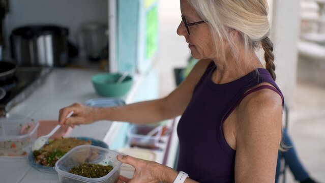 A woman selects delicious shrimp and fish tacos with lime and salsa at a food stand in Baja California Mexico