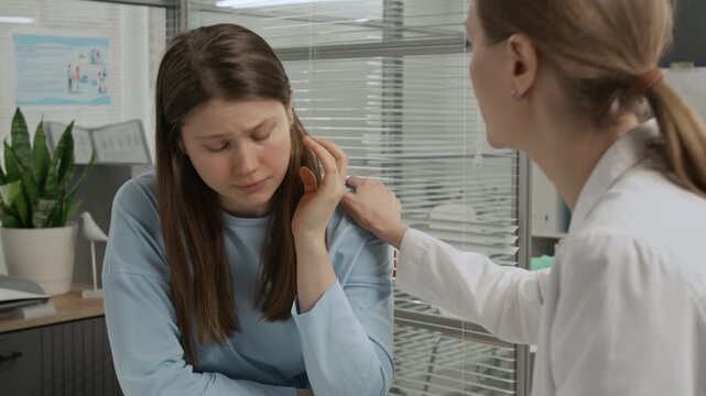 Tilt up shot of upset gen Z girl listening to female doctor informing her of negative ultrasound results during appointment in clinical setting