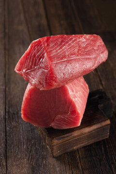 Fillet of fresh tuna fish for Japanese cuisine. Large piece of raw red tuna on wooden board. Natural omega. Large piece of raw fish steak for sushi and sashimi. Raw tuna steak.