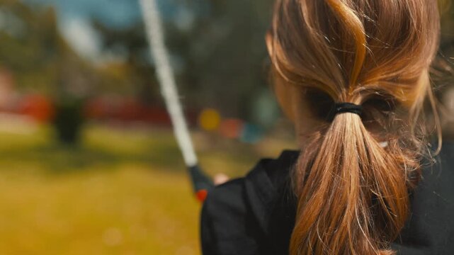 Girl plays with water hose in backyard during sunny afternoon