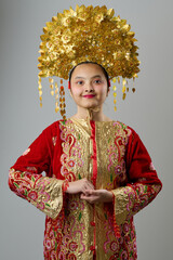 Fototapeta premium Traditional Headdress And Ornate Red Gold Costume Portrait Of A Young Indonesian Asian Girl For Festival Or Ceremony