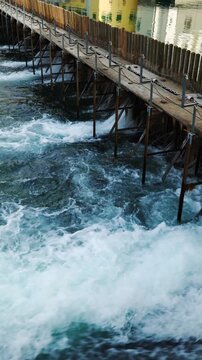 Panning shot of the rushing Reuss river and historic needle dam weir in Lucerne, Switzerland