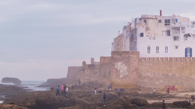 Essaouira, Morocco. Sunset view of Essaouira is a city and port on the Atlantic coast in Morocco, North Africa. Time-lapse with tourists, panning video