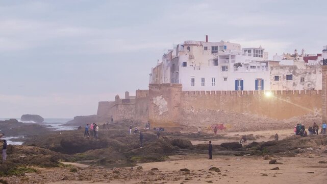 Essaouira, Morocco. Sunset view of Essaouira is a city and port on the Atlantic coast in Morocco, North Africa. Time-lapse with tourists, zoom in