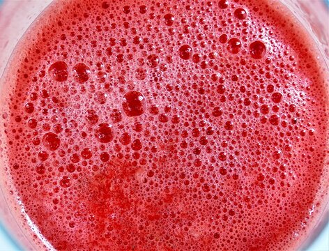 Fresh watermelon juice with bubbles and foam in a glass summer drinks background
