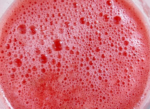 Fresh watermelon juice with bubbles and foam in a glass summer drinks background
