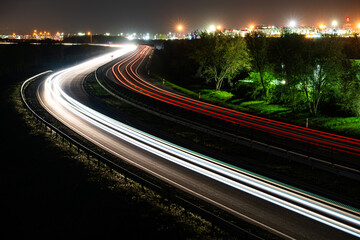 Highway light trails at night with city lights and long exposure © Roland