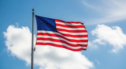 Obraz premium American flag waving in the wind against a blue sky