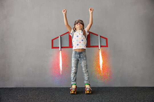 Happy child pretend to be astronaut. Funny kid with paper rocket. Little boy playing indoors