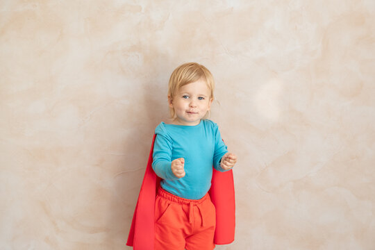 Little boy dressed as a superhero having fun at home