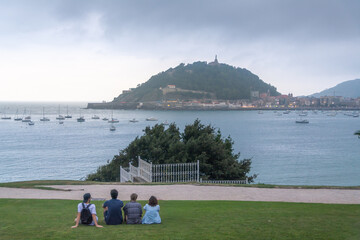 Obraz premium Group of friends enjoying panoramic coastal views of Monte Urgull and San Sebastian bay in Spain.
