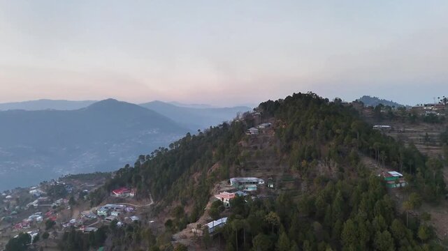 Aerial View of Mountain Village Nestled in Pine Forest During Twilight
