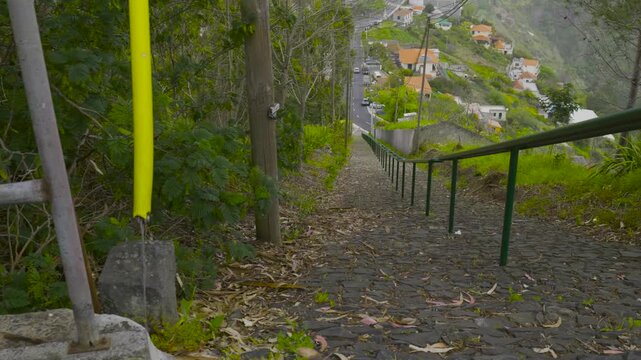 Point of view walking down a steep cobblestone downhill path in madeira