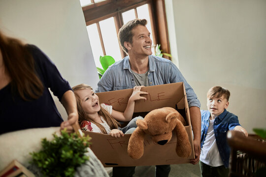 Smiling family moving boxes up stairs at new home