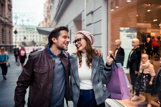 Happy couple shopping on city street