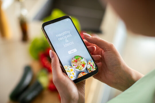 Person using healthy recipe app in home kitchen