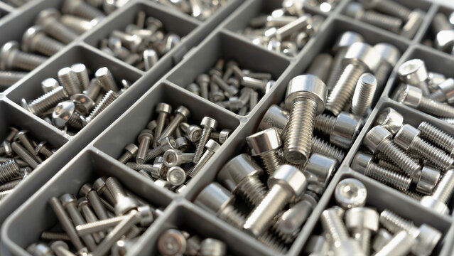 Metal fasteners in organizer box close up with selective focus