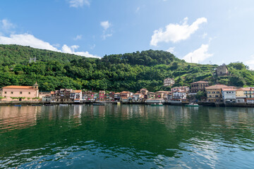 Fototapeta premium Traditional colorful houses reflected in the water at Pasai Donibane harbor in the Basque Country near San Sebastian, Spain.
