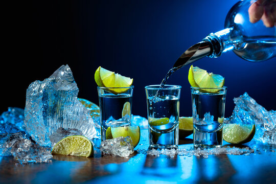 The tequila is poured from the bottle into shot glasses.