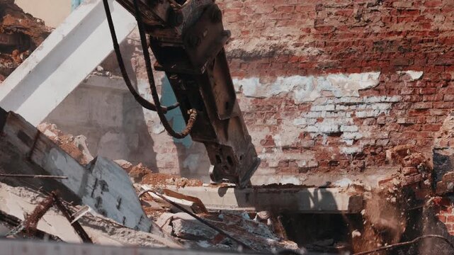 Excavator hydraulic hammer breaking concrete and brick during demolition