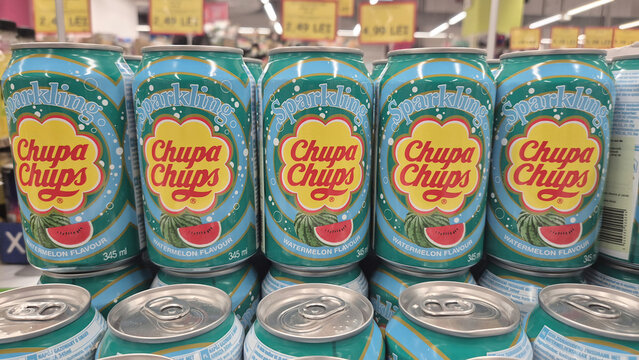 Row of teal Chupa Chups sparkling watermelon soda cans on a grocery shelf with yellow price tags in the background. Picture taken on April 29, 2026 in Bucharest, Romania.