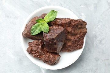 Chocolate chunks and mint leaves on grey table, top view © New Africa