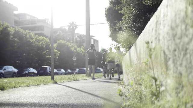 Groupe de coureurs en ville sur une voie de tramway au lever du soleil, chaussure en gros plan, lumi&egrave;re belle bleue , vert jogging, runner