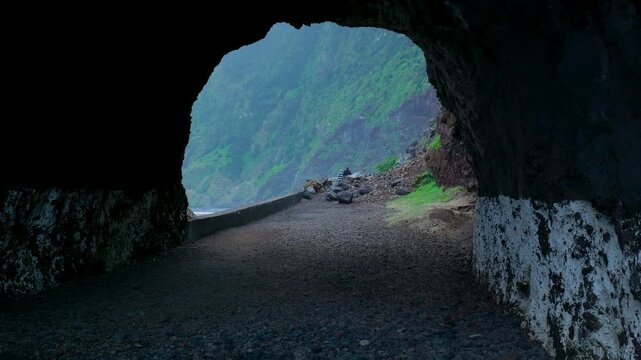 Point of view shot exiting a dark tunnel towards the ocean coast in madeira