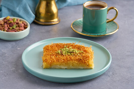 Traditional middle eastern cheese kunafa dessert . Turkish, arabic traditional sweets. Served with sugar syrup and pistachio