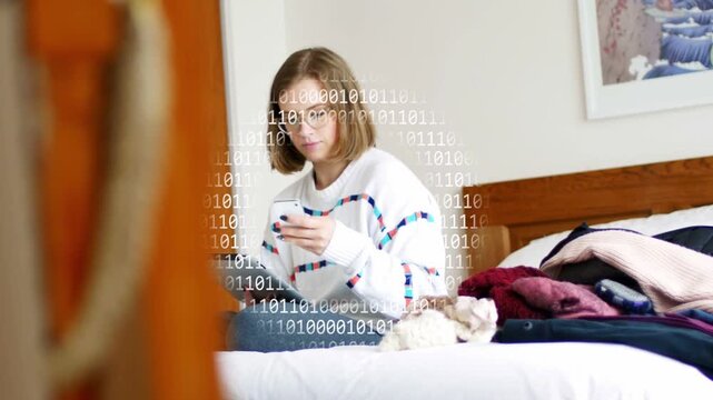 Camera panning woman sitting on bed alternating phone tablet, binary overlay circling her for tech