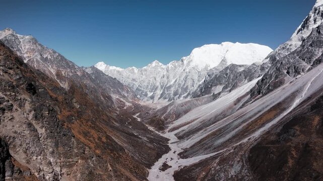 A close aerial view of rugged Himalayan peaks with patches of snow and exposed rocky surfaces.