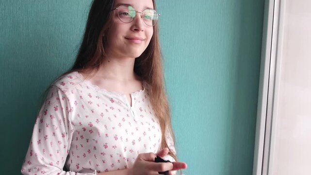Teen girl putting on clean eyeglasses, vision correction routine, everyday lifestyle and personal care concept.