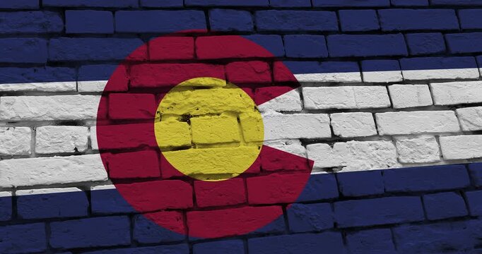 A panning video of a brick wall with the colorado state flag of the United States of America