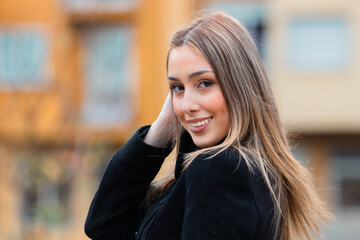 Fototapeta premium young woman with long blonde hair smiling on the street