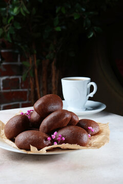 Chocolate brownie Potato. Traditional sweet dessert made from butter and cocoa. There is white cup of tea or coffee on table