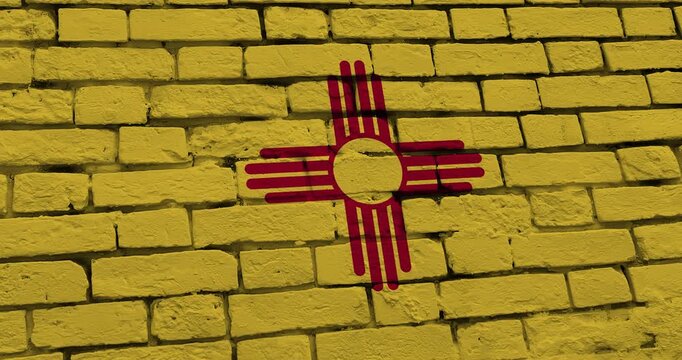 A panning video of a brick wall with the new mexico state flag of the United States of America