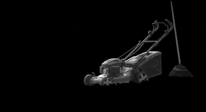A black and white studio shot of a push lawn mower positioned next to a long-handled garden rake against a solid black background