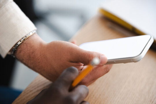 A person holds a smartphone and a pencil, suggesting a moment of work or study.