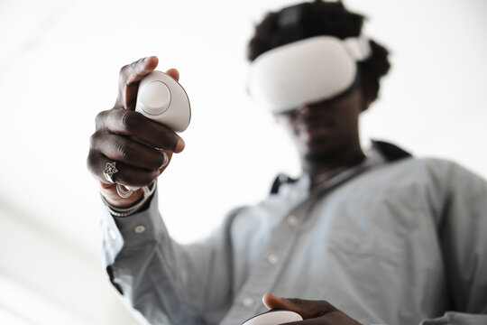 A man wearing a virtual reality headset holds controllers, engaging with an immersive digital experience.