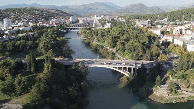 Aerial forward flight over Moraca river with bridges and greenery, Podgorica, Montenegro.