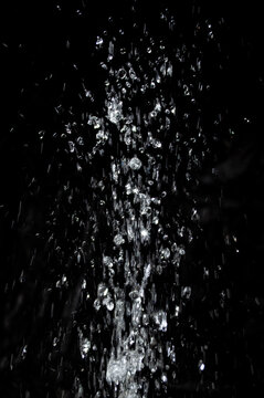 Water splashes in a dark setting during nighttime, creating a dynamic visual effect