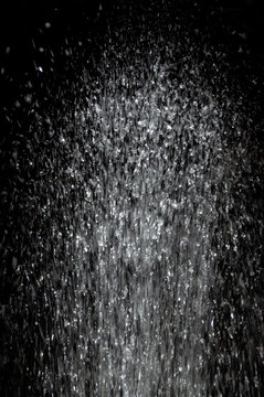 Water splashes in a dark setting during nighttime, creating a dynamic visual effect