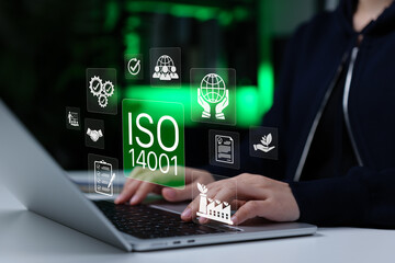 ISO 14001 environmental management system compliance concept. Person using laptop with...