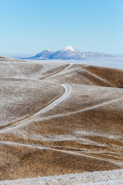 View of winding roads and mountain peaks in Caucasus in sunny winter day