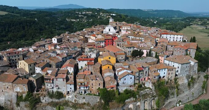 Panoramic drone view Orte Italy cityscape. Medieval town stone rooftops green valley forest sunny day. Italian tourism destination urban landscape Lazio holiday travel exploration landscape nature