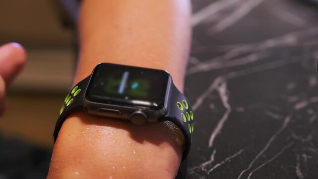 smartwatch beeping after water removal close-up view, user interacting with device on wrist, moisture clearing function activating sound signal, wearable technology operation and health tracking usage