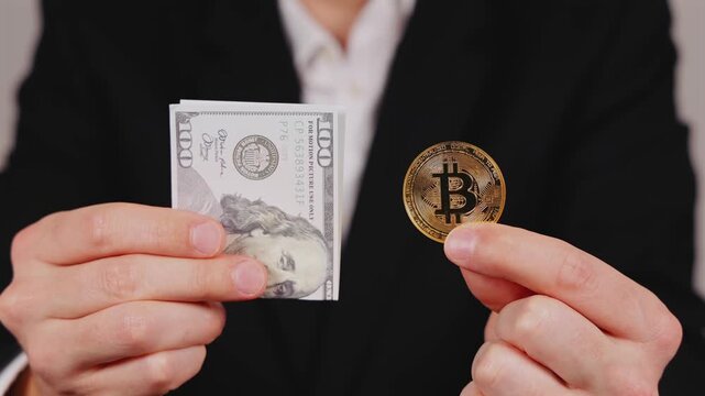 Une personne tenant un billet en dollar et un bitcoin dans ses mains, symbolisant les devises num&eacute;riques et papiers. 