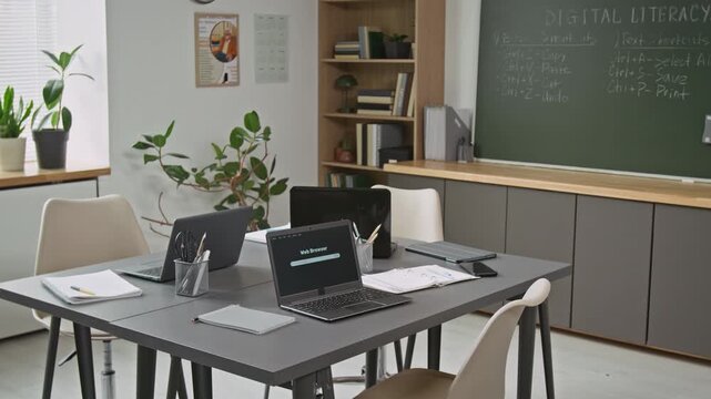 Background image of modern computer class interior with open laptops on shared table and study supplies, no people, copy space